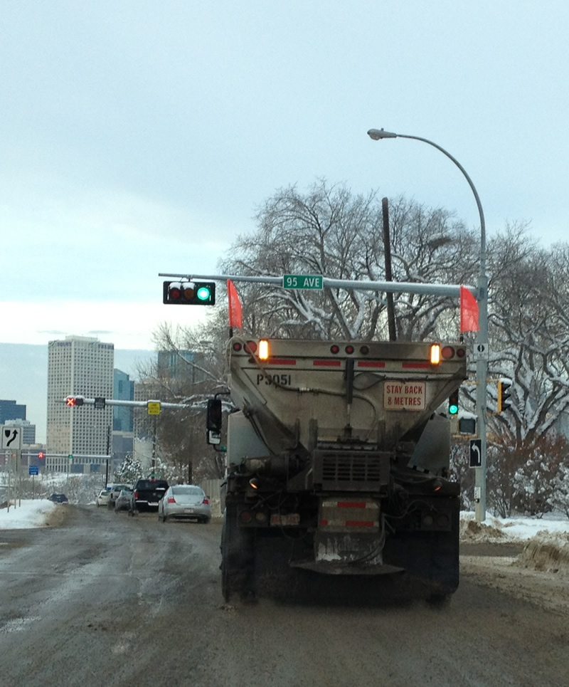 Camion répendeur de sable sur la neige. 